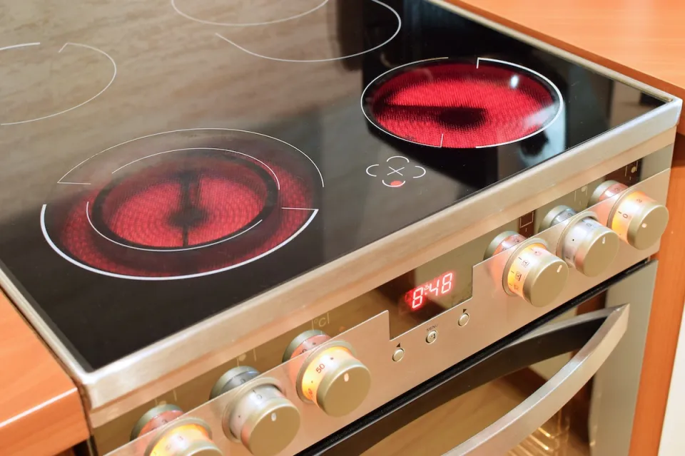Close-up of electric stove range with front burners red-hot.